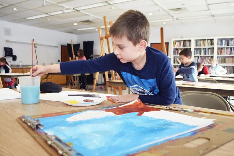 Luca Melendez, 8, creates a Harry Potter-inspired owl scene during painting class for kids
