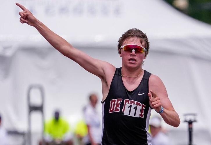 De Pere's Grady Lenn acknowledges the crowd as he enters the home stretch of the boys 3,200-meter run during the first day of the WIAA state track and field meet June 5 at Veterans Memorial Stadium in La Crosse.