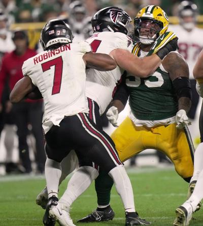 Green Bay Packers defensive tackle Chris McClellan (55) is blocked from tackling Atlanta Falcons running back Bijan Robinson (7)