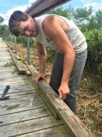 Kishwauketoe summer intern Joel Myers performs boardwalk repairs