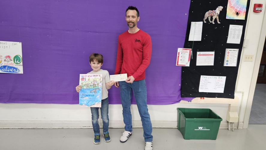 Fontana Elementary School student Harrison Hachmeister receives a $50 check for taking second place in a state poster contest