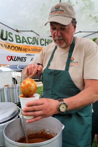 Fontana resident John Hughes ladles up bacon chili at the Walworth County Food & Diaper Bank's fundraising booth