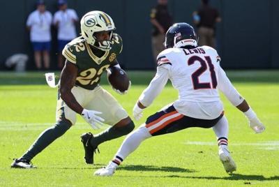 Green Bay Packers running back Pierre Strong Jr. carries the ball defended by Chicago Bears defensive back Cam Lewis.