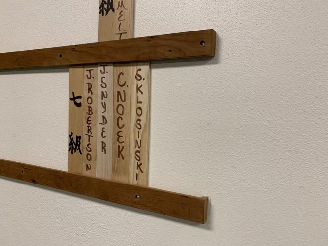 A wall along the One Point Center Aikido studio lists some students' rankings