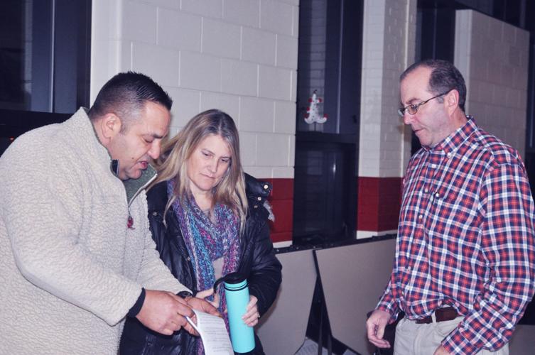 Dimitri Anagnos, left, Alderwoman Cindy Flower and Tom Reed discuss survey questions