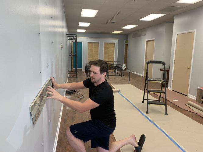 Tyler Dempsey, owner of Holistic Connections, prepares to install a rock wall