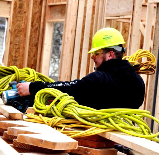 A Balsitis Contracting employee prepares some equipment to begin construction work.