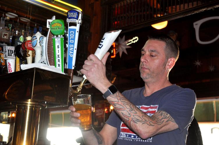 Dan Kuhl, bartender at Hogs & Kisses Restaurant and Nightclub, pours a drink for a customer