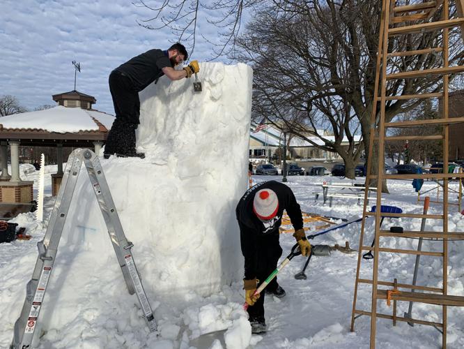 Joe Goral of Illinois team "Cave People from Space" carves out a piece of the team's sculpture, while teammate Brian Hierstein shovels around the sculpture