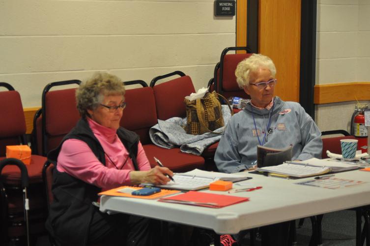 Diane Bauman and Dolleen Brenton prepare to check in voters