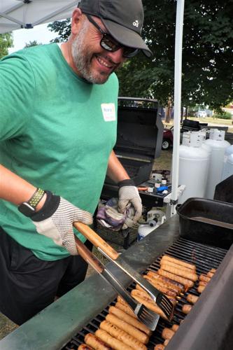 Rotarian Steve Torrez grills brats at the Geneva Lake West Rotary Club's 2022 Corn & Bratwurst Festival