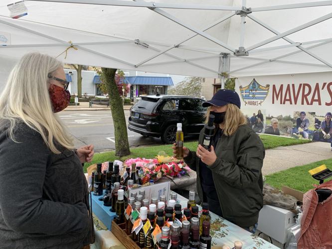 Judy Gatesman purchases some olive oil from vendor Marva Papadatos