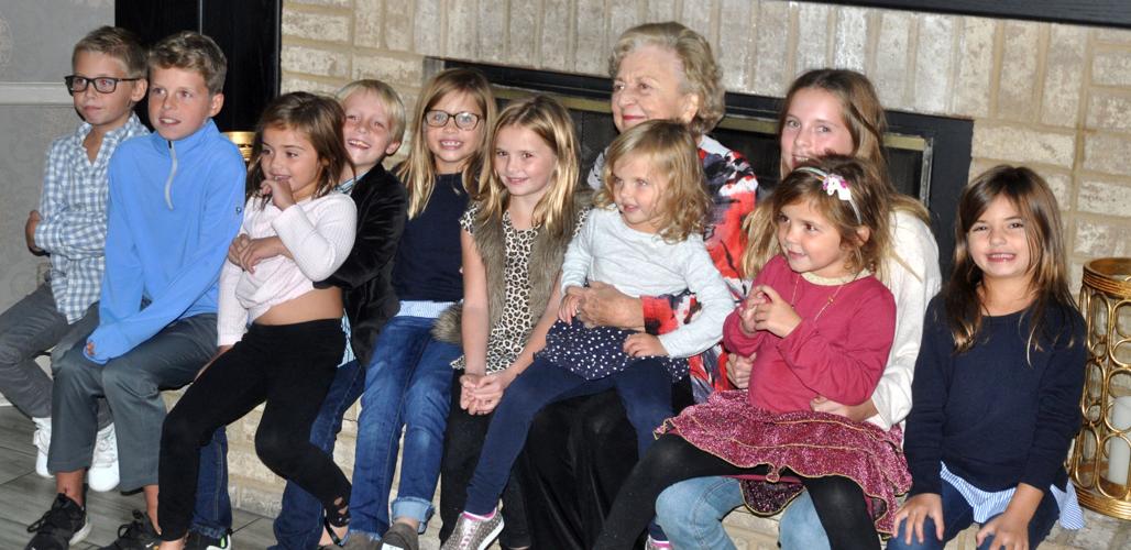 Marilyn Schawk, co-founder of The Geneva Inn, is flanked by several of her great-grandchildren