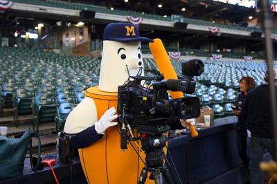 Barrel Man, one of the Brewers mascots operates a TV camera before the Milwaukee Brewers faced the Colorado Rockies for the home opener at Miller Park in Milwaukee, April 6, 2015.
