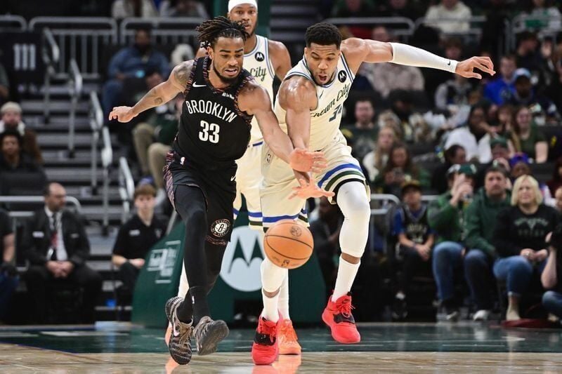Nov 29, 2025; Milwaukee, Wisconsin, USA; Brooklyn Nets center Nicolas Claxton (33) and Milwaukee Bucks forward Giannis Antetokounmpo (34) reach for a loose ball in the first quarter at Fiserv Forum. Mandatory Credit: Benny Sieu-Imagn Images