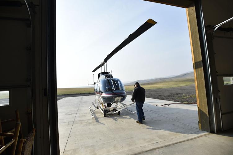 Bill Galt wheels his Bell Jet Ranger helicopter out of the hangar
