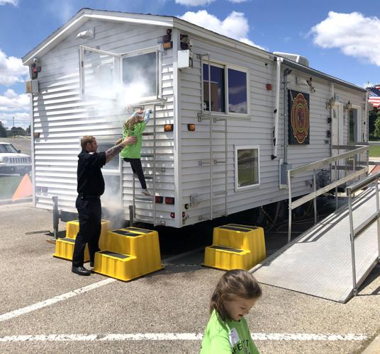 Children from a recent Safety Town program use a smoke house to practice fire safety