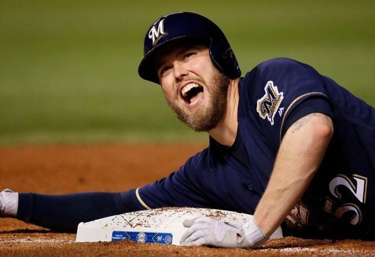 Milwaukee Brewers starting pitcher Jimmy Nelson (52) yells as he dives back into first base after hitting a single off Chicago Cubs starting pitcher John Lackey (not pictured) during the fifth inning at Wrigley Field on Sept. 8, 2017.
