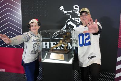 Fans pose with a Heisman Trophy at the NFL Scouting Combine Experience in Indianapolis.