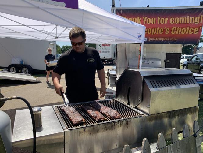 Riley Atkinson of Just North of Memphis BBQ prepares some ribs