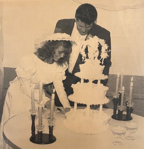 Sabrina and Elwood cut wedding cake