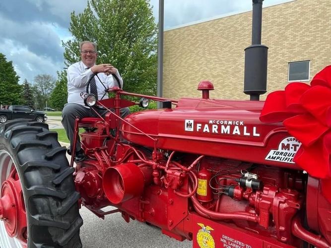 Retiring Badger High School agriculture instructor Larry Plapp sits on a restored tractor