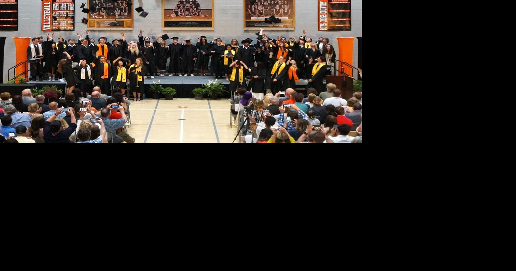 Graduates toss their mortarboards in celebration at the Williams Bay