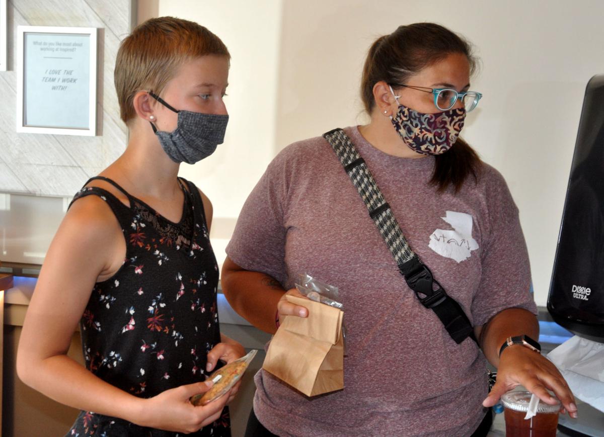 Morgan Brewster, left, and Emily Brewster pick up their order at the Inspired Coffee shop