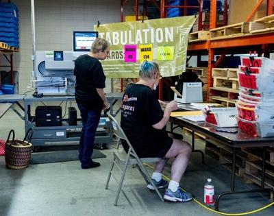Election workers run absentee ballots through a tabulation machine at the Milwaukee central count in Milwaukee, Wisconsin on Aug. 11, 2026. J