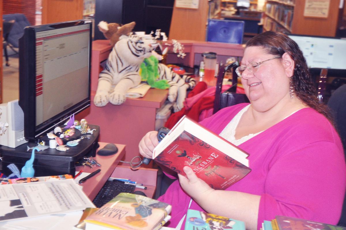 Sara Soukup, director of youth services at Lake Geneva Public Library, checks in some books (copy)