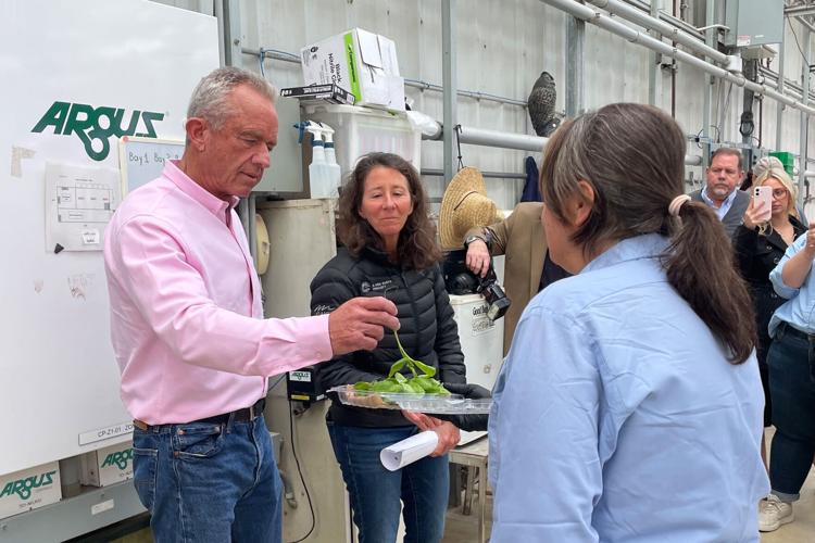 During a stop on his“ Take Back Your Health” tour, Health and Human Services Secretary Robert F. Kennedy Jr. and his principal deputy chief of staff, Stefanie Spear, munch on pesticide-free produce.