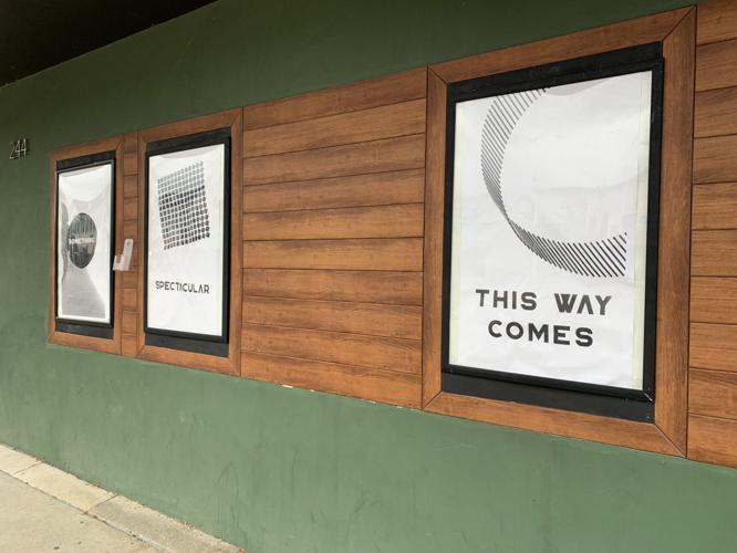 Poster signs in the three front windows of the Geneva Theater hint at "something spectacular"