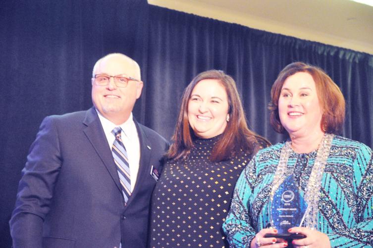 Shannon McCarthy, center, surrounded by Steve Magnuson, vice chairperson of the Visit Lake Geanve Board
