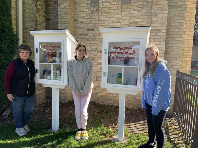 Terri Smith, Emma Konecny and Olivia Wolff stand next to the blessing boxes