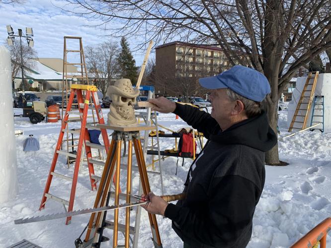 James Malkowski of Wisconsin team "Snow Cronies Too" reviews a model of his team's sculpture