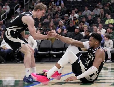 Milwaukee Bucks guard AJ Green (20) helps forward Giannis Antetokounmpo (34) to his feet during the first half of their game against the Indiana Pacers Sunday, March 15, 2026 at Fiserv Forum in Milwaukee, Wisconsin.