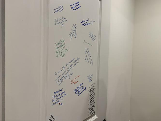 Several residents and business representatives write their well wishes to the Rivera family on the wall of the Habitat for Humanity home