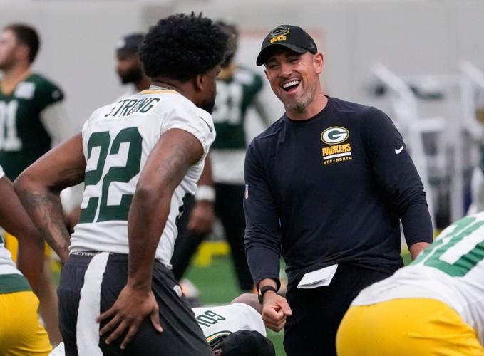 Green Bay Packers head coach Matt LaFleur shares a laugh with running back Pierre Strong Jr. (22) during practice on Wednesday,