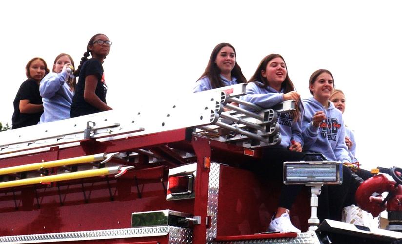 Williams Bay High School's volleyball teams ride atop a fire truck in the school's 2023 homecoming parade