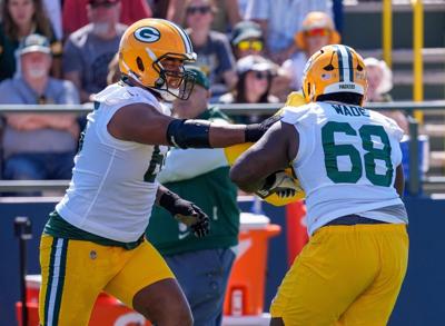 Green Bay Packers offensive linemen Aaron Banks (65) and Dillon Wade (68) run through a drill during the first day of training