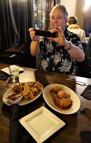 Bill Soplanda takes a photo of Tuscan Tavern & Grill appetizers for posting to the "Aloha Boys" Facebook Page