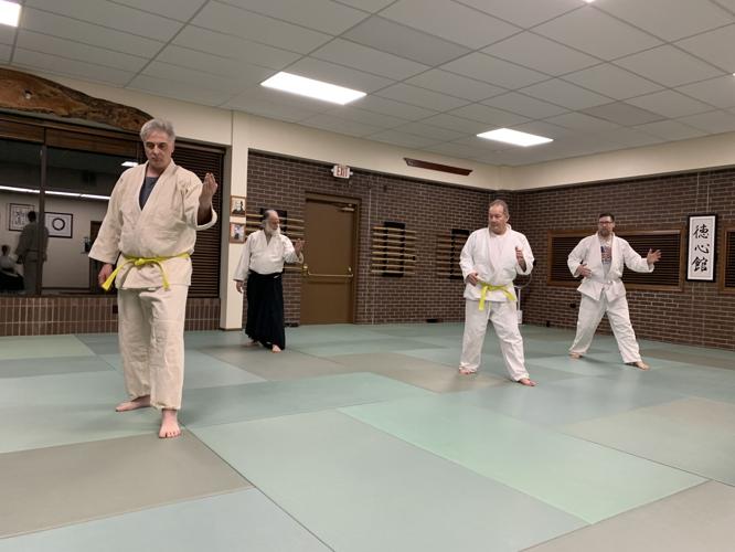 Students warm up before a class at the One Point Center Aikido studio