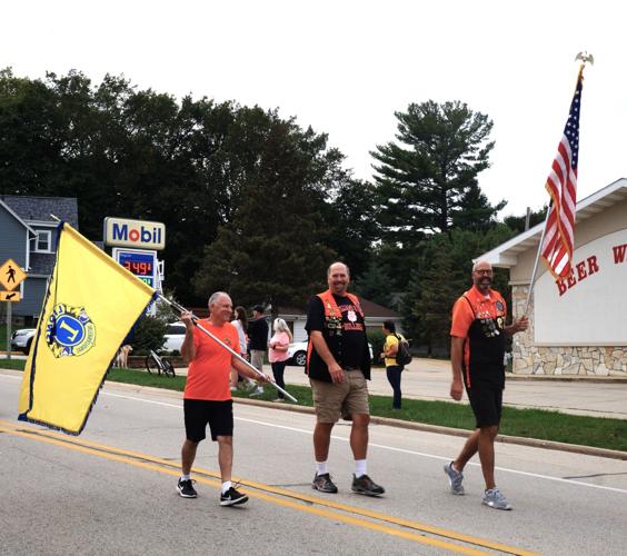 Members of the Williams Bay Lions Club process in the 2023 Williams Bay High School homecoming parade