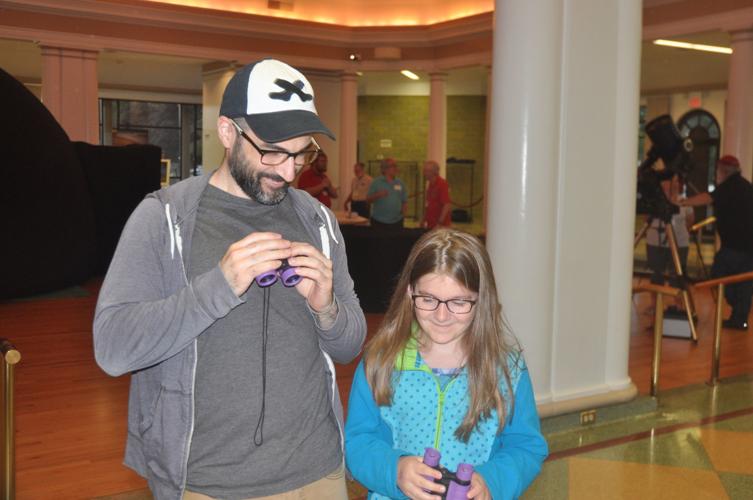 Don Francis and his 8-year-old-daughter, Lily, prepare to look through a pair of binoculars
