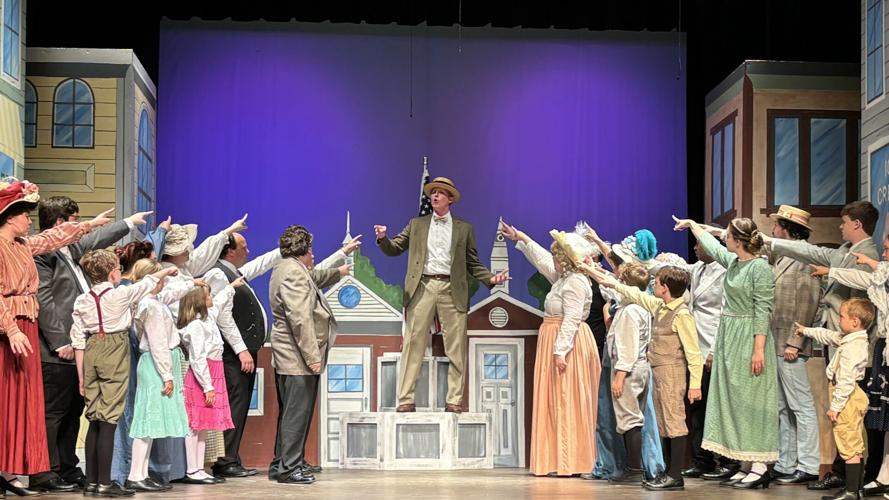 Cevin Moses, portraying Harold Hill, warns River City residents of potential "Trouble"