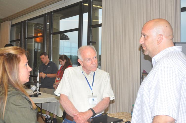 Richard Huttas, center, talks to Alysondra Delalis and Peter Delalis about the history and architecture