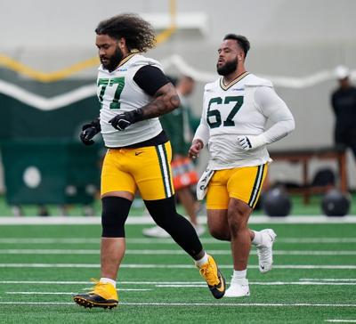 Green Bay Packers offensive tackle Jordan Morgan (77) and Green Bay Packers offensive tackle Donovan Jennings (67) warm up