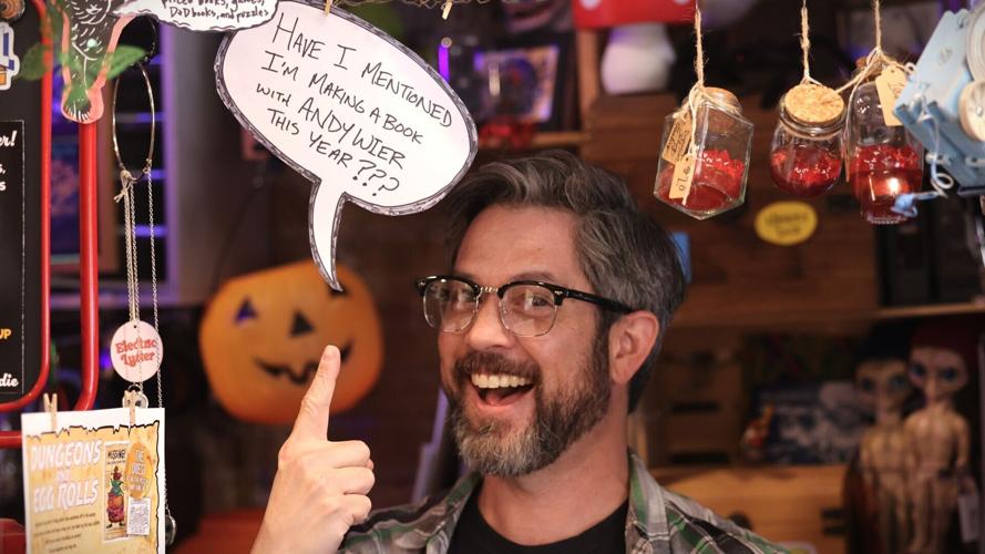 Donovan Scherer points at Andy Weir sign