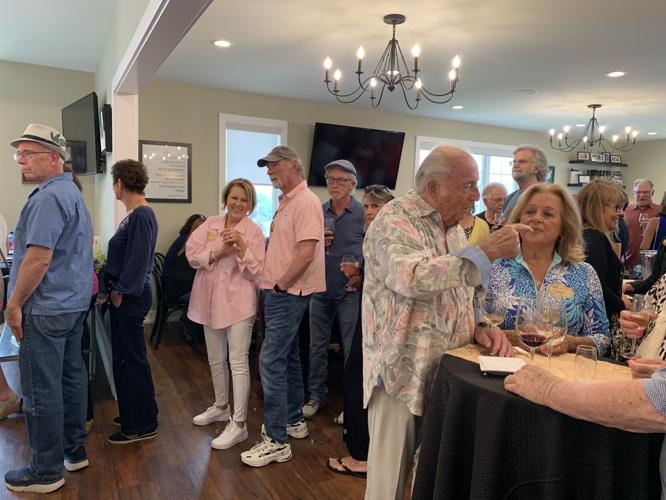 Guests line up to sample food and drinks during the grand opening celebration for Lake Geneva School of Cooking's new location