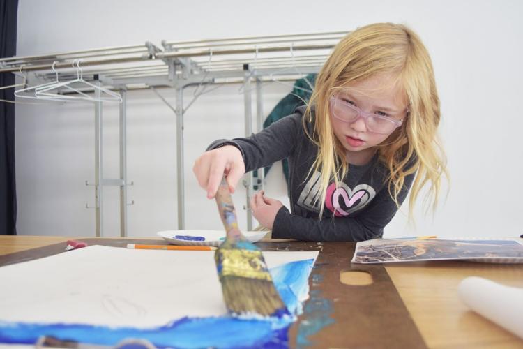 Atlas Brown, 7, uses a paint brush on her winter wildlife scene at Wustum art museum